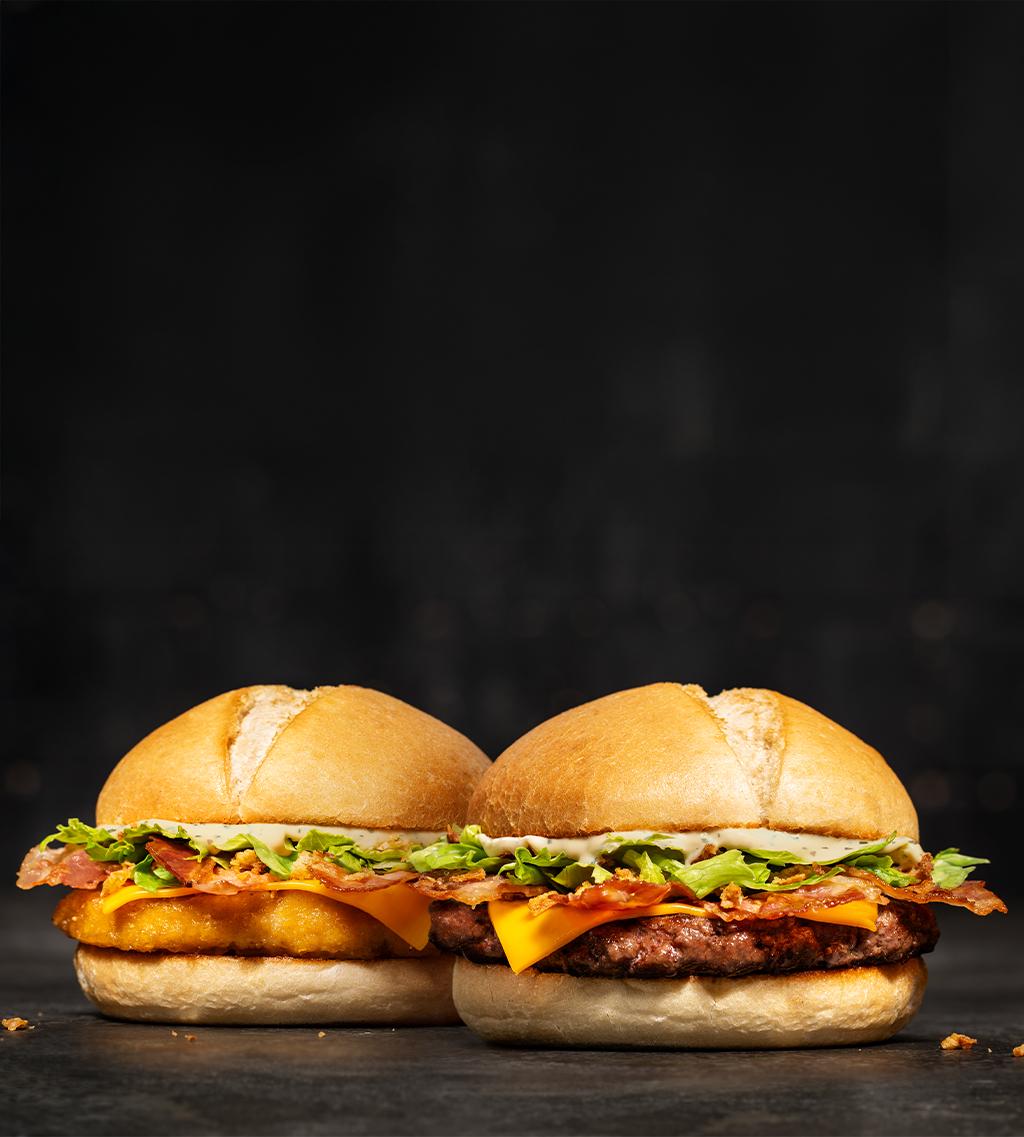 2 burgers en édition limitée : pain pistolet avec sauce barbecue blanche, 4 tranches de bacon, cheddar, salade, oignons frits, et au choix poulet pané ou steak haché de bœuf.